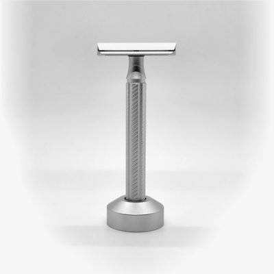 Silver safety razor on a light gray background